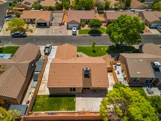 Tile roof, rear patio with concrete surface, and green lawn