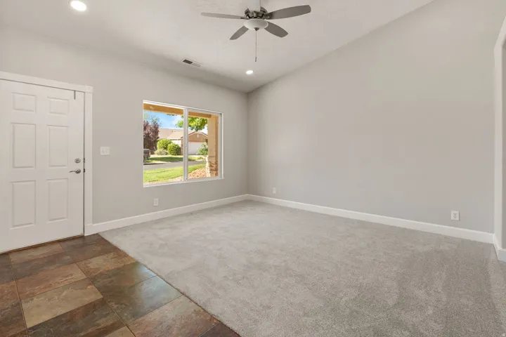 Vaulted ceiling with recessed lighting and a ceiling fan