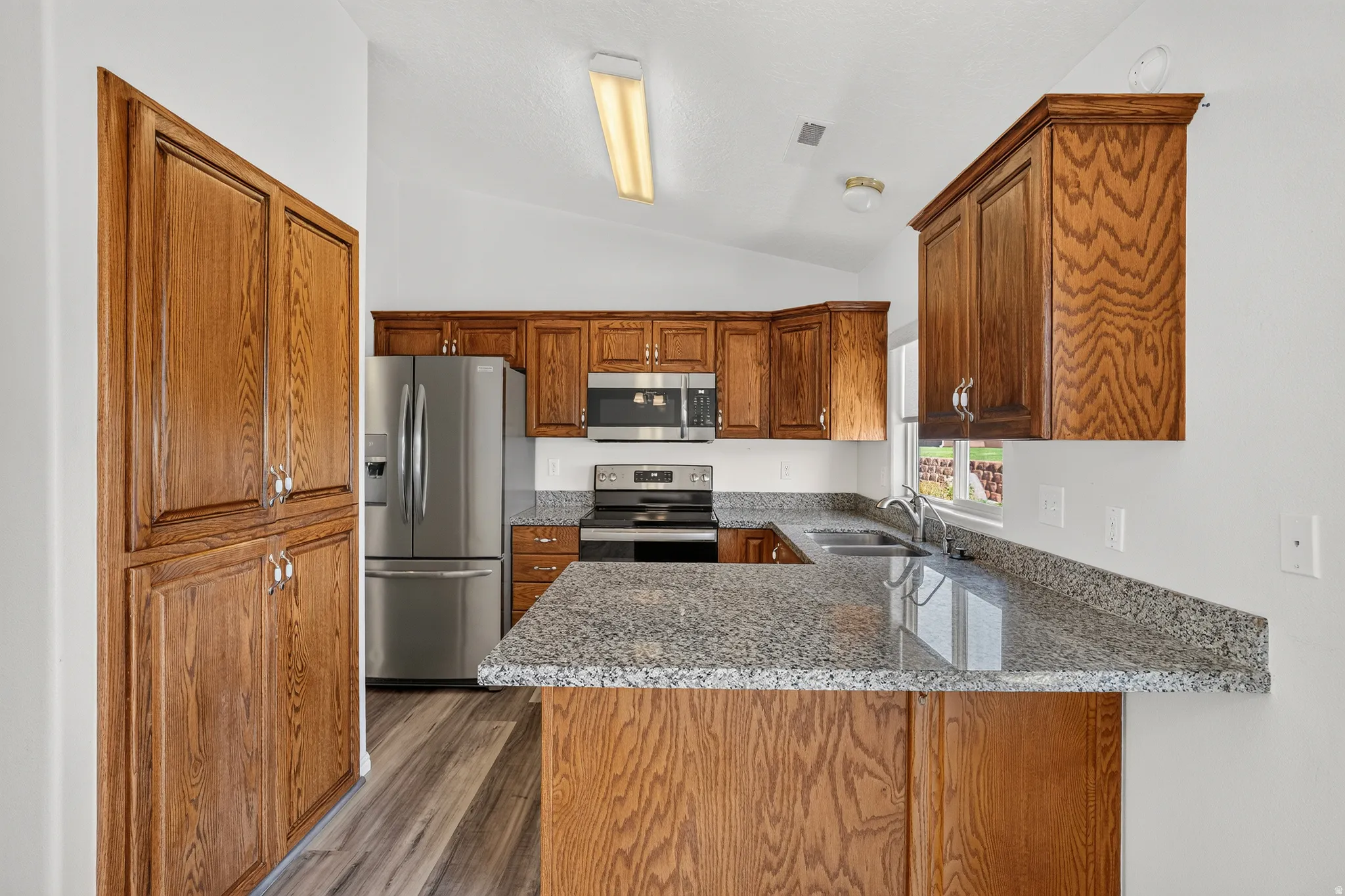 Kitchen featuring wood-finish cabinetry, granite countertops, and stainless steel appliances