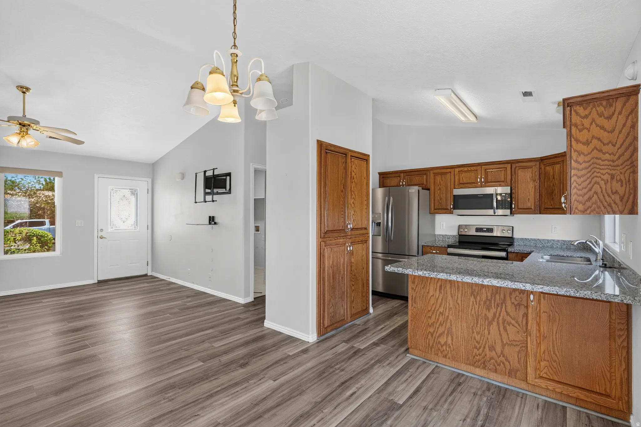 Kitchen featuring wood-finish cabinetry, stainless steel appliances, and a granite-style countertop