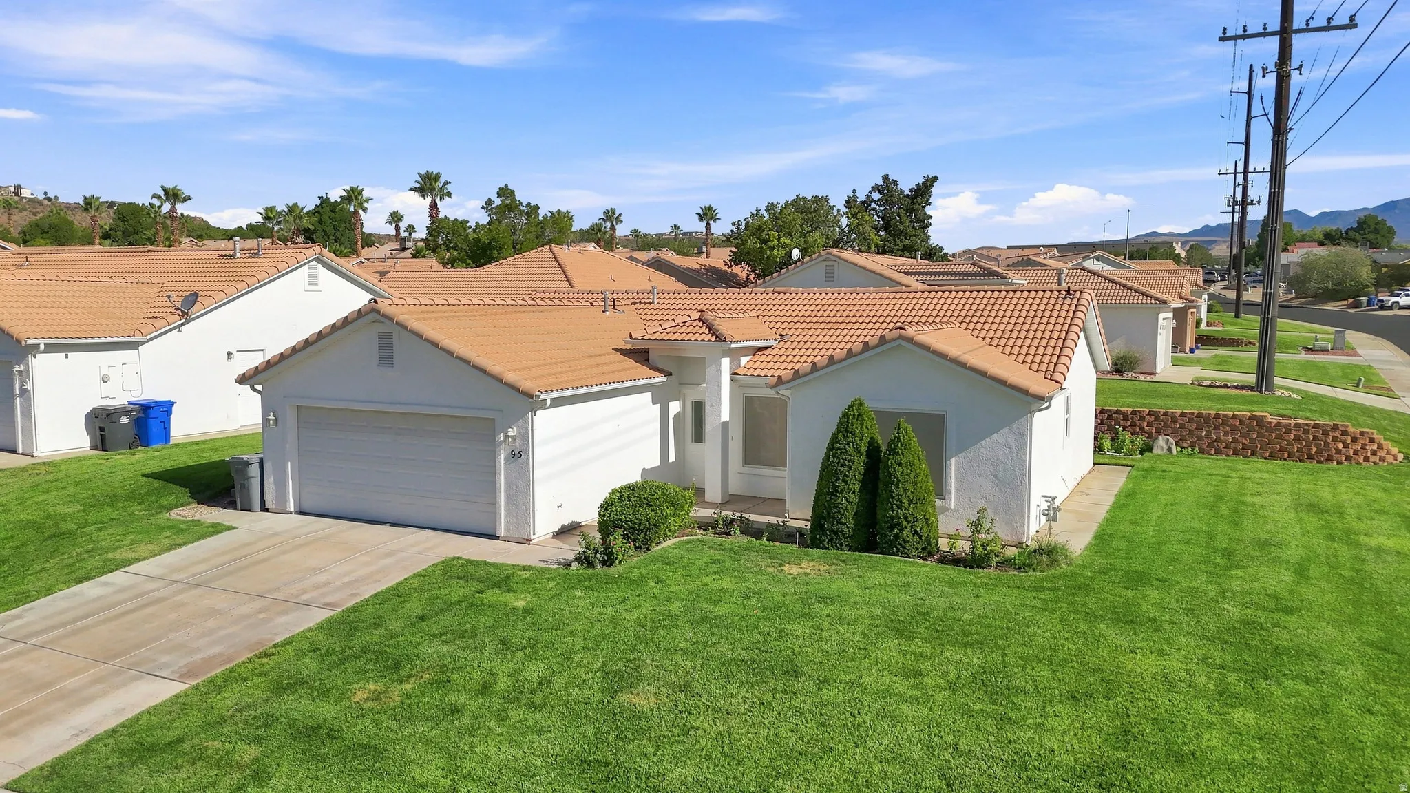 Single-story residence featuring a tile roof, stucco exterior, and an attached two-car garage