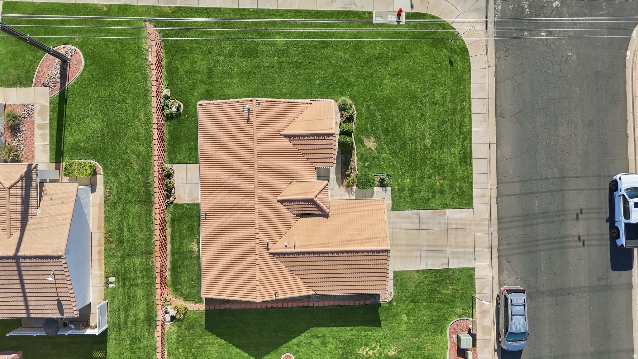 Aerial view showcasing a contemporary residence with a distinctive peaked roof design and multiple geometric rooflines