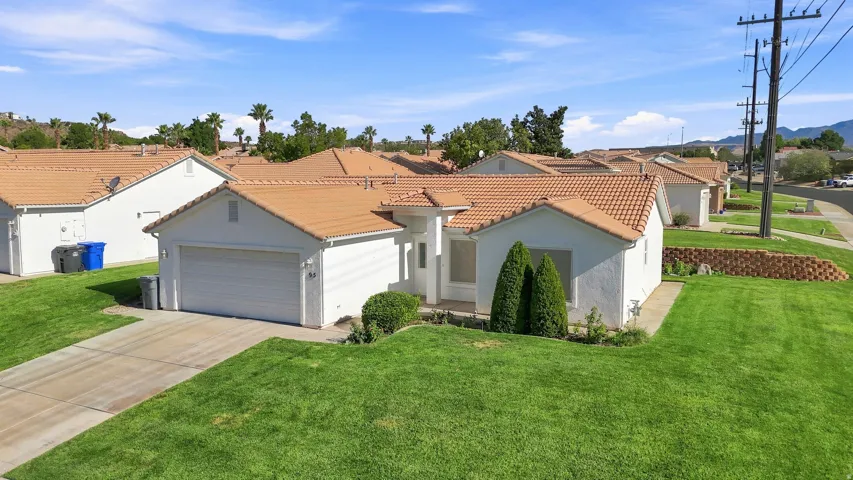 Single-story residence featuring a tile roof, stucco exterior, and an attached two-car garage