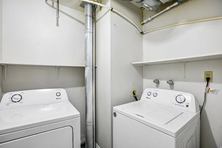 Laundry area with built-in shelving and appliance hookups