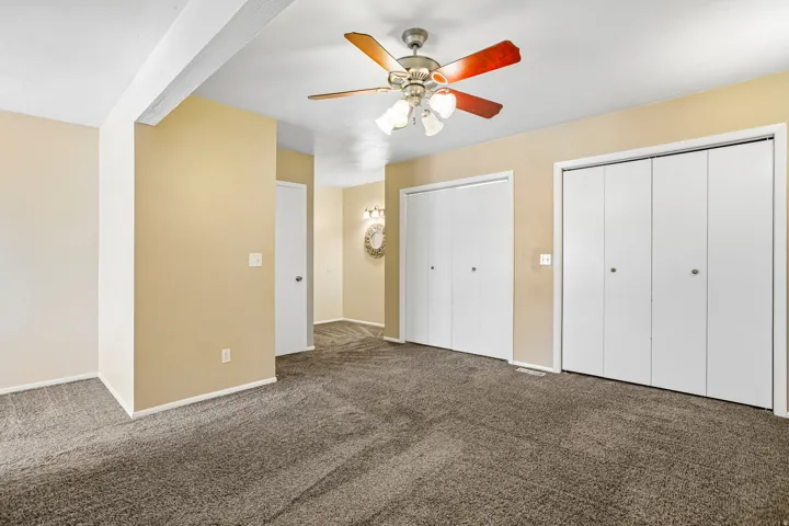 Neutral-toned walls complement the textured carpet flooring