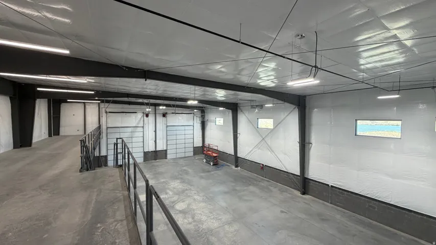 Spacious warehouse interior with concrete flooring and exposed structural beams