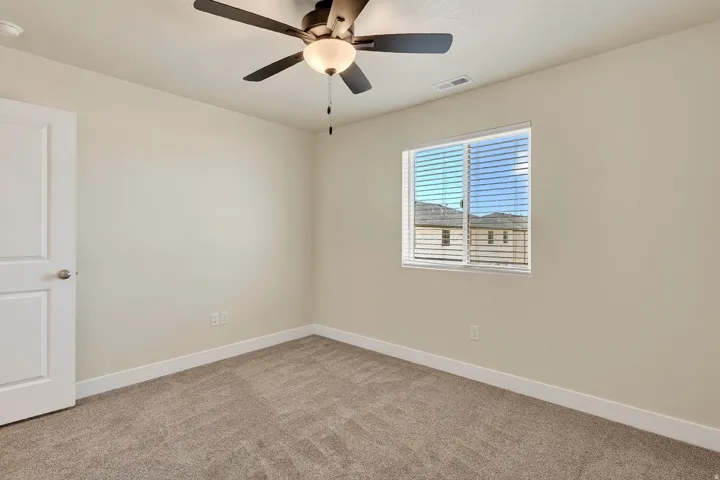 Neutral wall finishes, recessed window, ceiling fan with integrated lighting, and carpet flooring