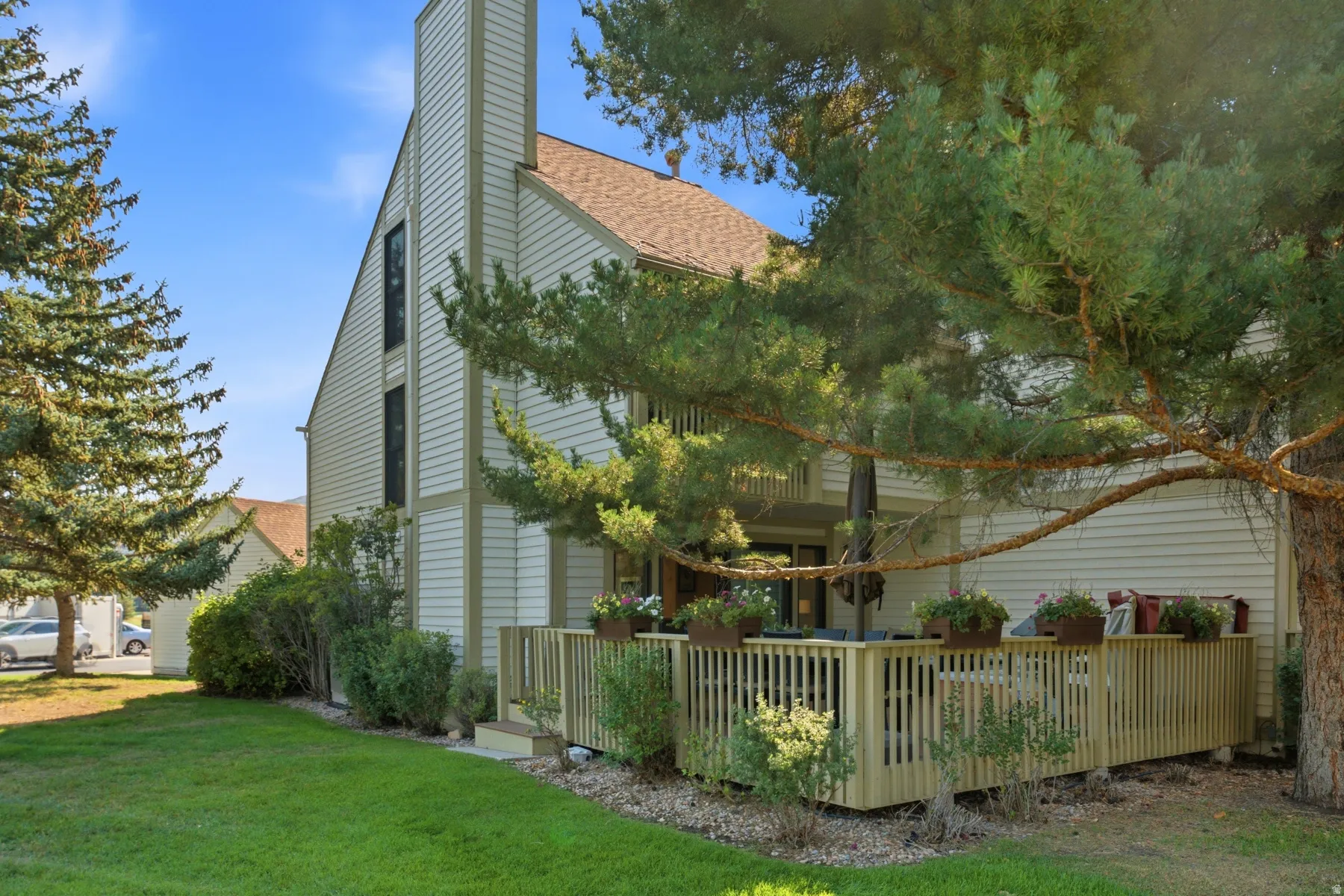 Wood-clad exterior with a prominent chimney, multi-pane windows, and a private wood deck