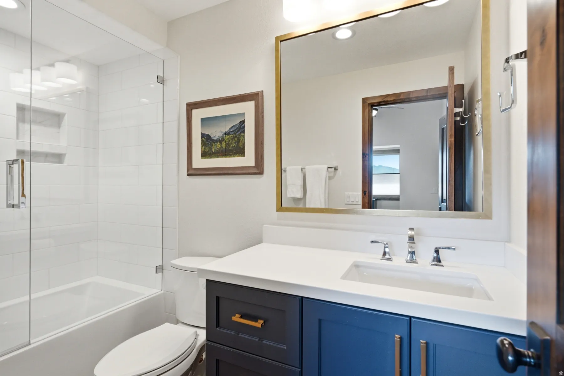 Glass-enclosed tub and shower with white subway tile