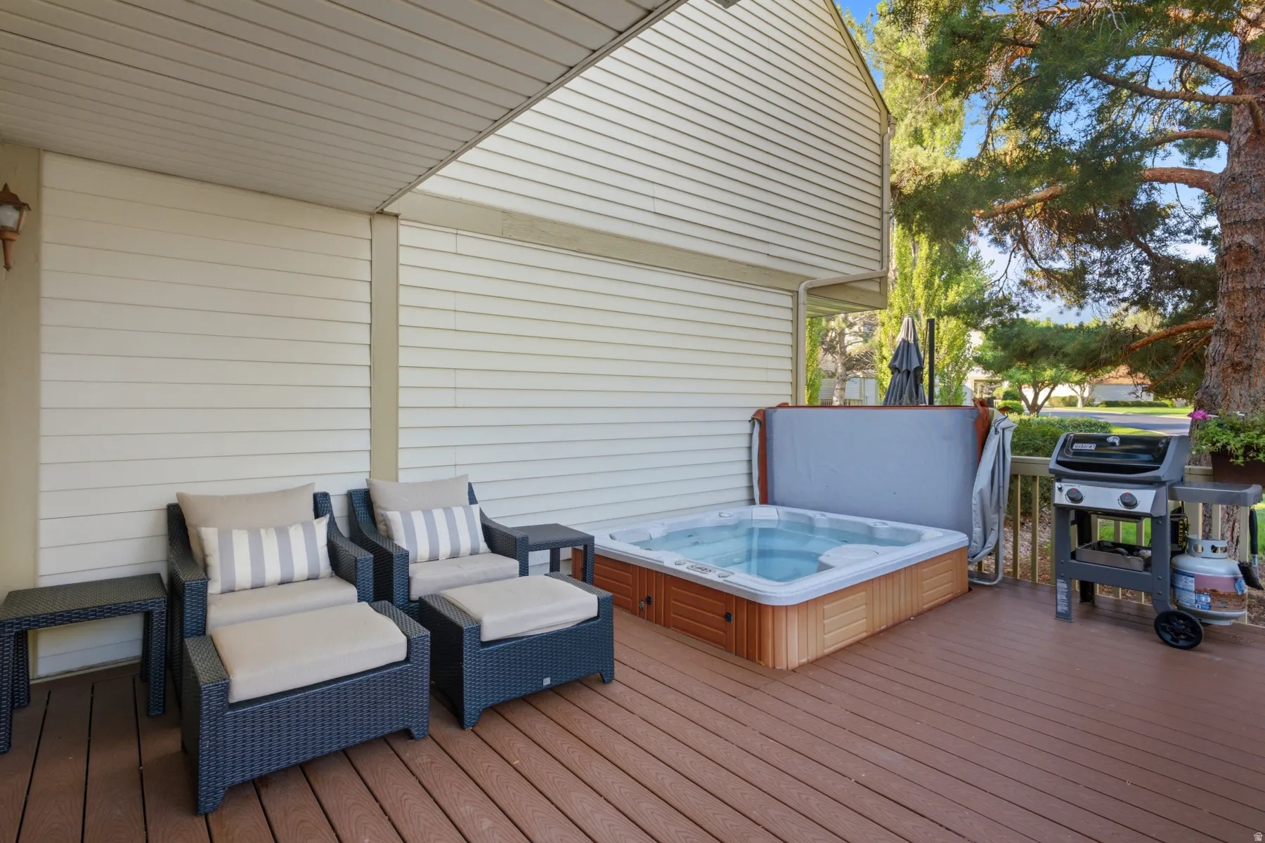 Spacious composite deck featuring a built-in hot tub and exterior siding