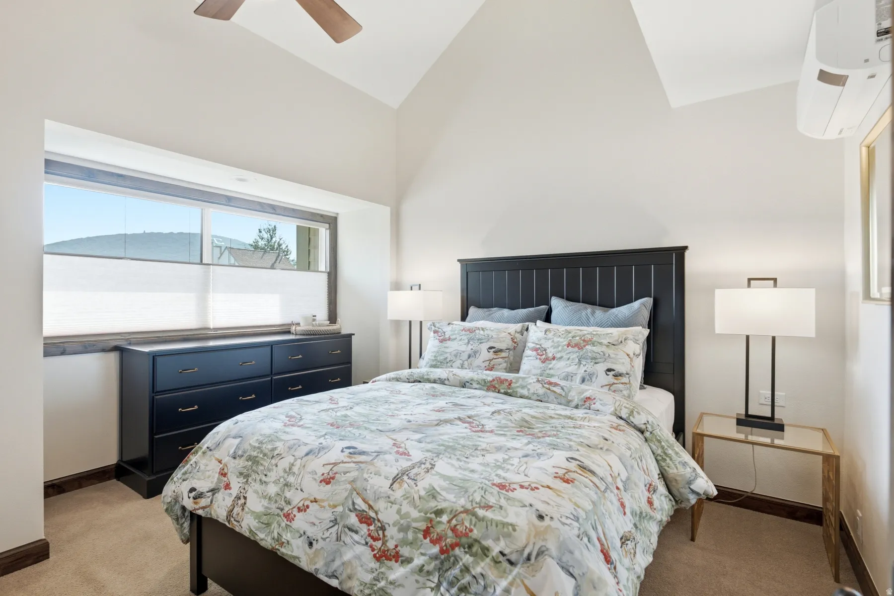 Vaulted ceiling with a ceiling fan, mini-split air conditioning unit, and a window with blinds