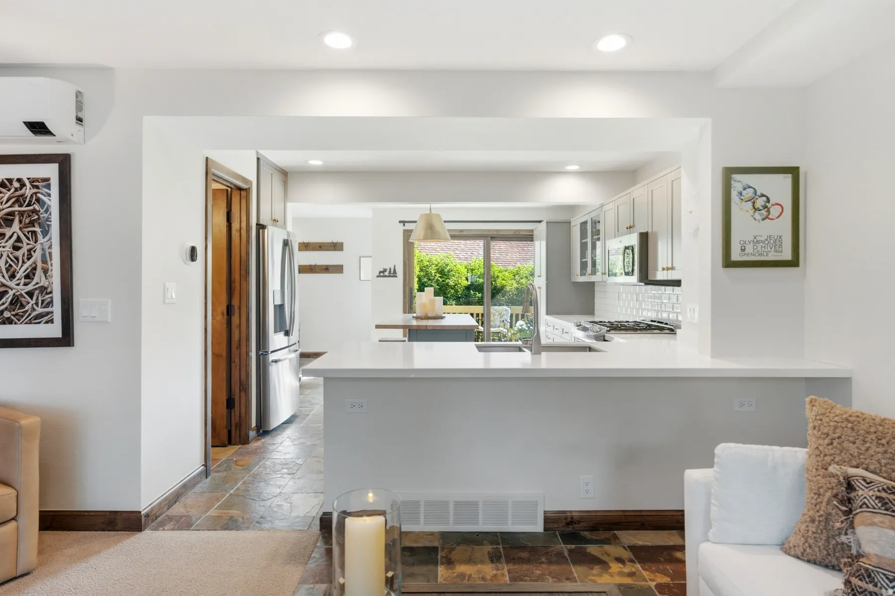 Kitchen with light cabinetry, stainless steel appliances, white subway tile backsplash, and light countertops