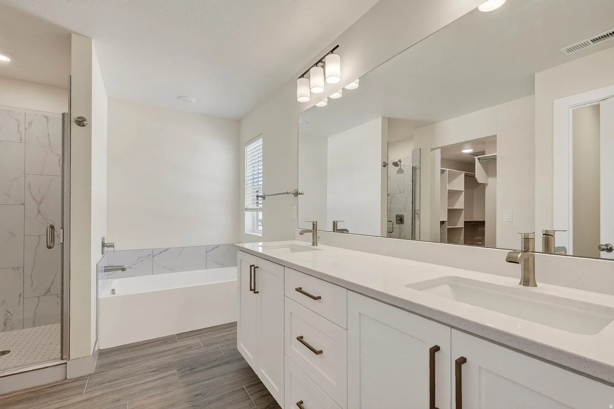 Double vanity with undermount sinks, bronze hardware, and large mirror