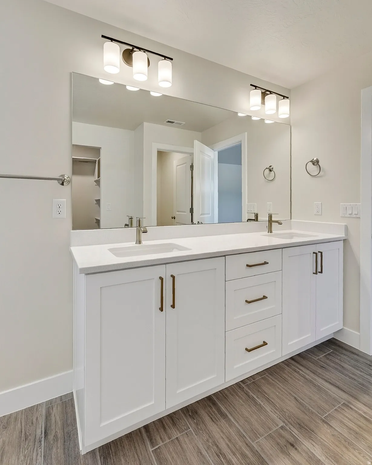 Dual vanity with white cabinetry and integrated sinks, complemented by a large wall-mounted mirror