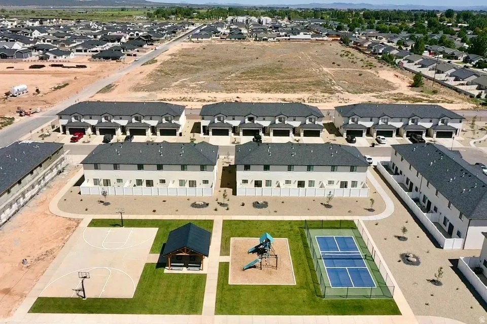 Community green space with a basketball court, playground, and tennis court
