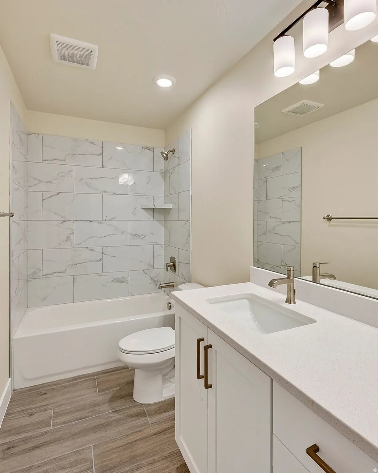 Bathroom featuring a white vanity with bronze hardware, a white integrated sink, and a large mirror