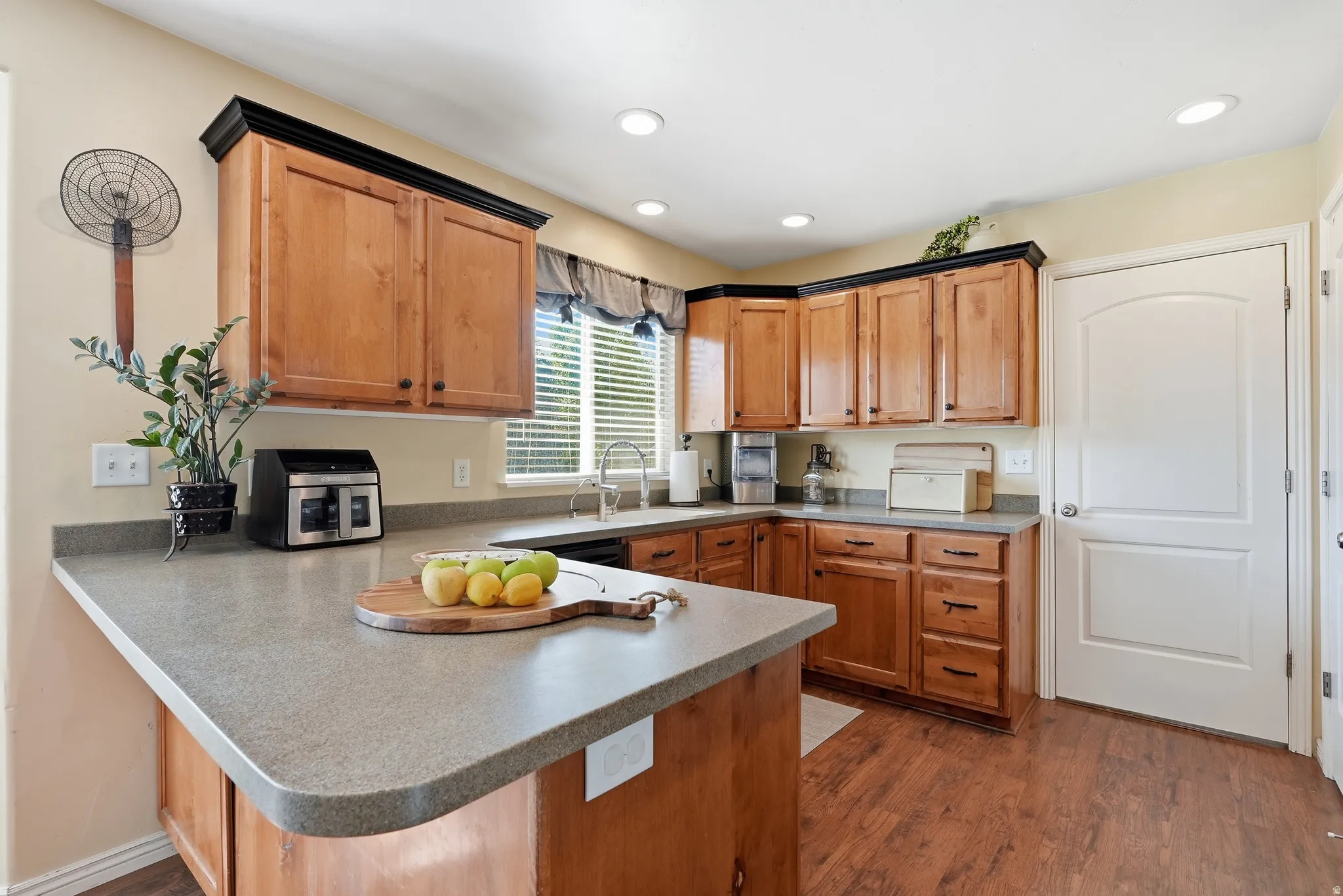 Kitchen featuring wood-finish flooring, recessed lighting, and a window with blinds