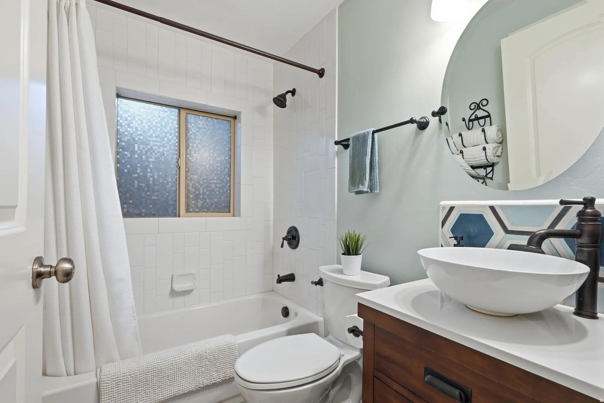 Contemporary bathroom featuring a white vessel sink, dark wood-finish vanity, and a tub with white subway tile surround