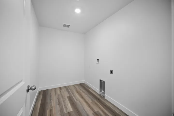 Utility room featuring wood-finish flooring, recessed lighting, and white walls