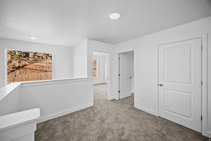 Plush carpeting throughout, crisp white walls, recessed ceiling lighting, and panel interior doors