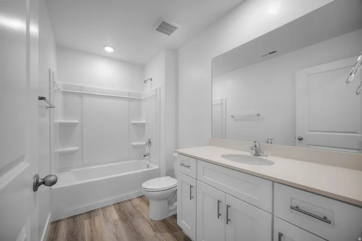 Bathroom featuring a vanity with a light-toned countertop, undermount sink, and white cabinetry