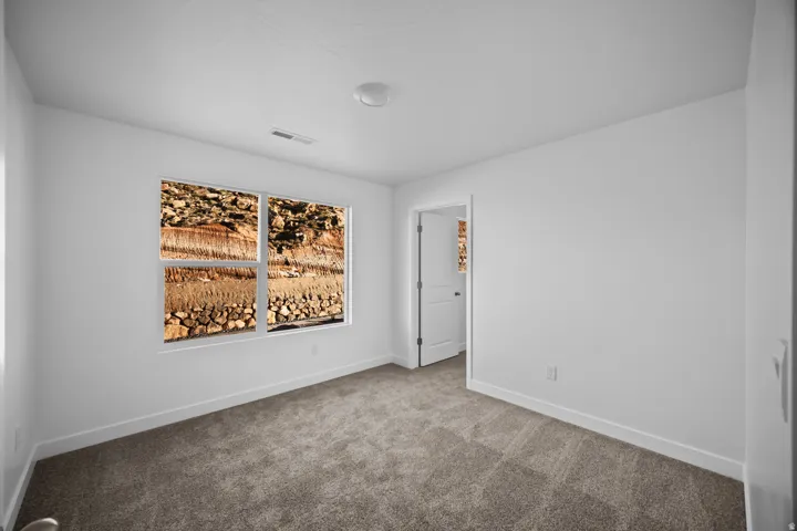 Carpeted flooring, white walls, white trim, recessed lighting, and a white interior door