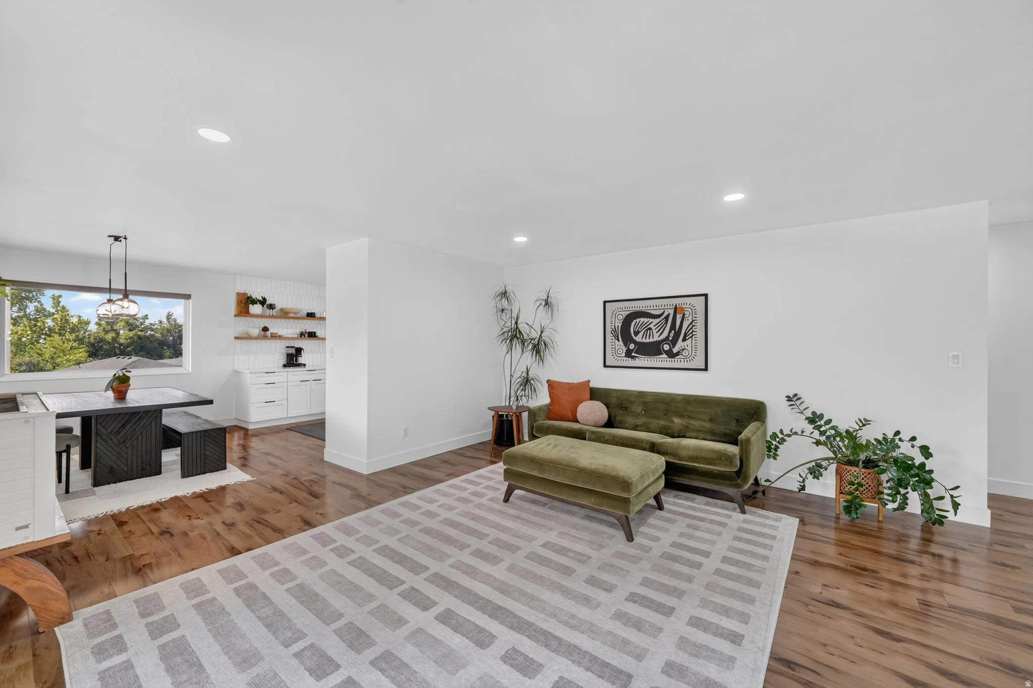 Open-concept living area featuring hardwood flooring throughout, recessed lighting, and multiple zones for entertaining