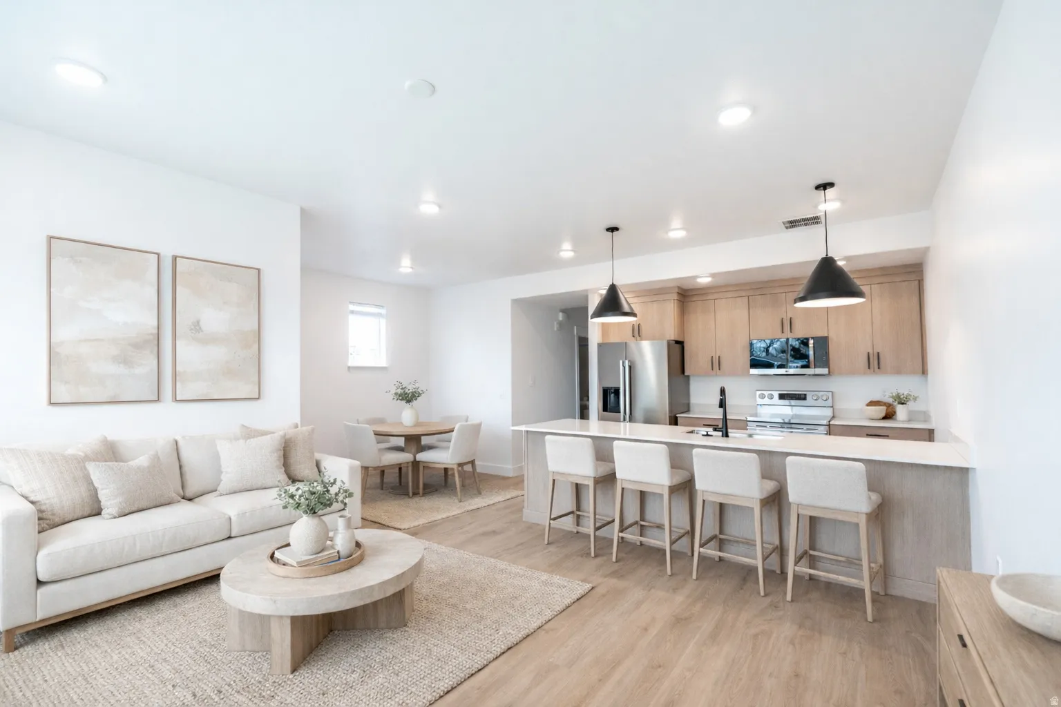 Open-concept living space featuring wood-finish flooring, recessed lighting, and a kitchen island with pendant lighting