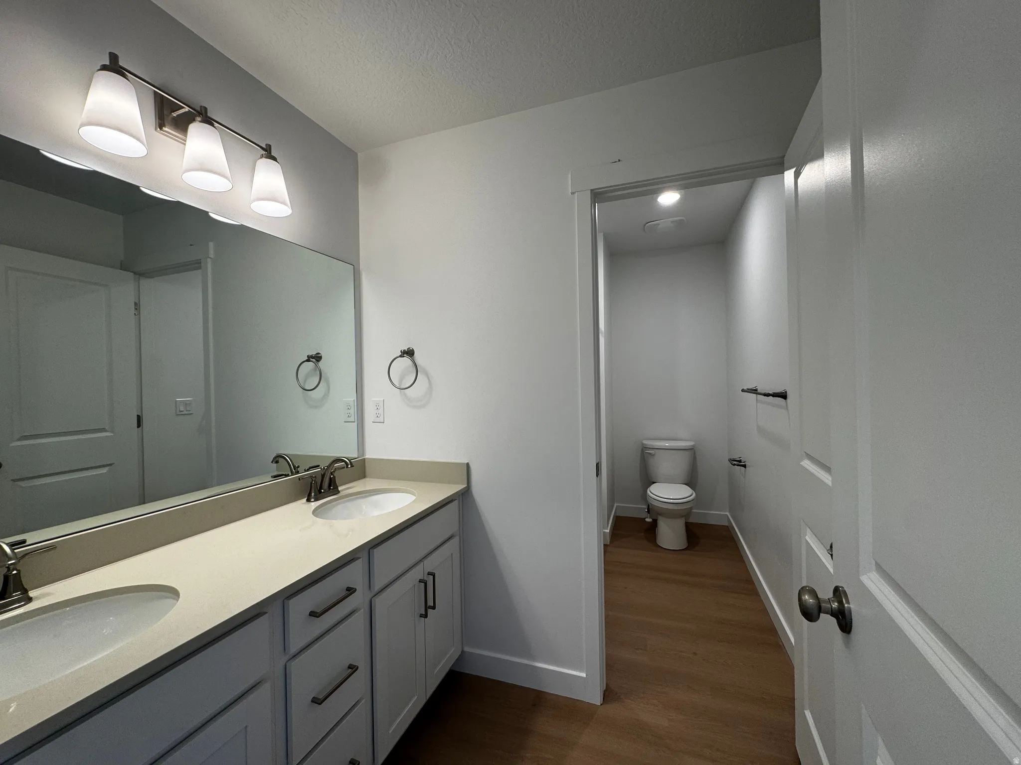 Dual sink vanity with light-toned countertop, white cabinetry, and brushed nickel hardware