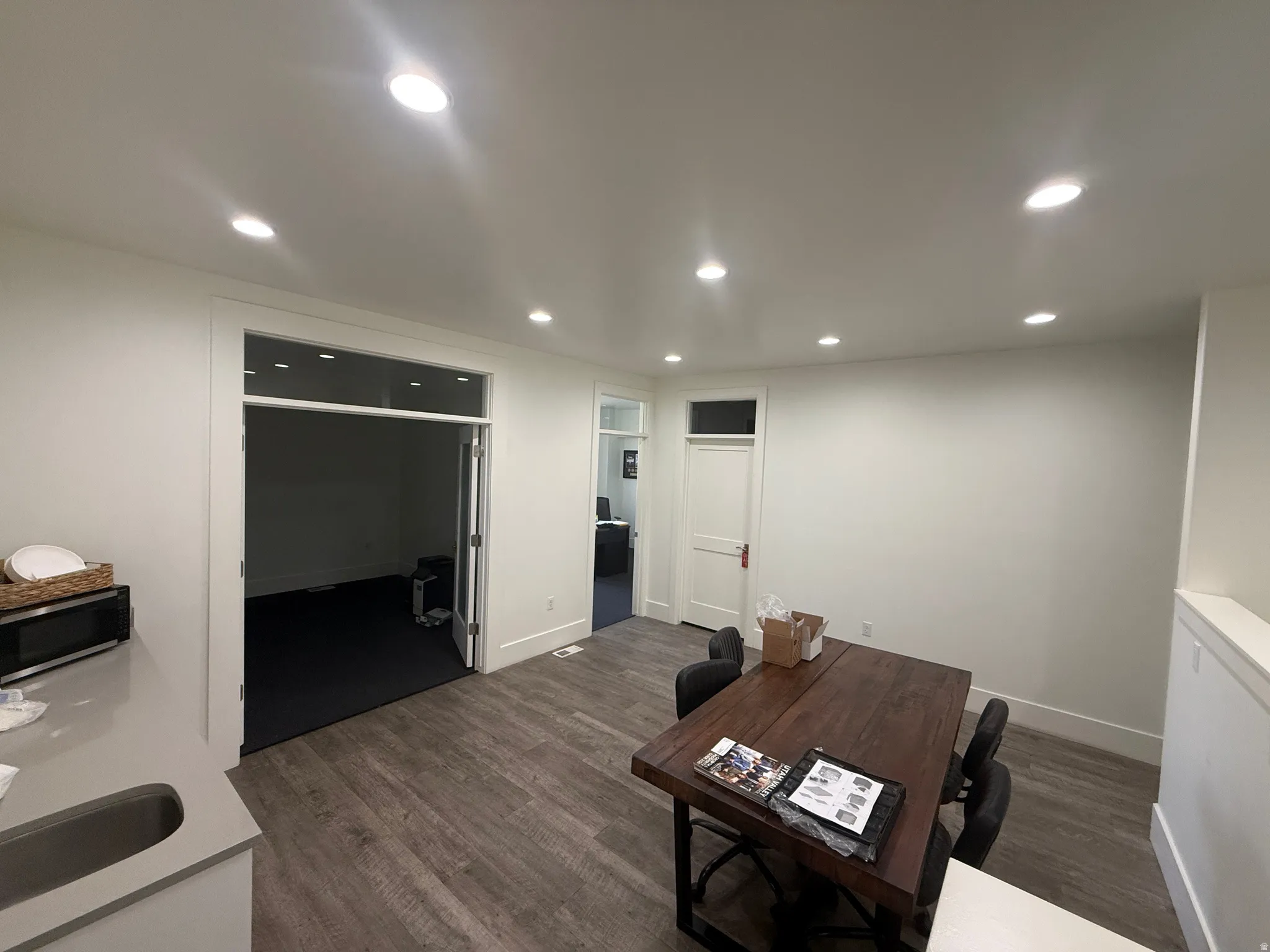 Recessed lighting, wood-finish flooring, light-toned walls, and a built-in counter with an undermount sink