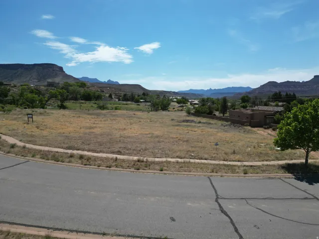 Expansive land parcel featuring natural terrain, mature trees, and mountainous scenery