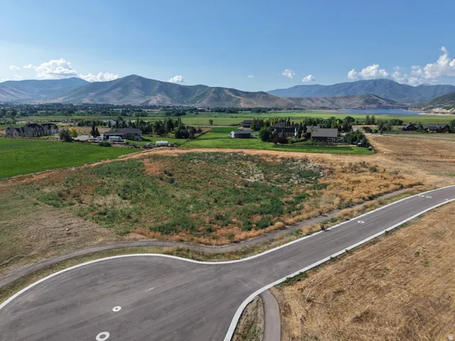 Expansive lot offering mountain scenery, a paved roadway, and open land