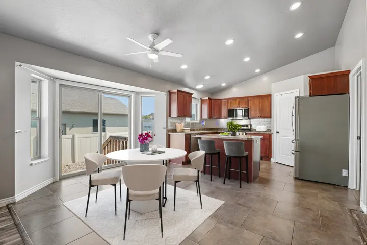 Spacious kitchen featuring rich wood cabinetry, a central island with bar seating, and stainless steel appliances