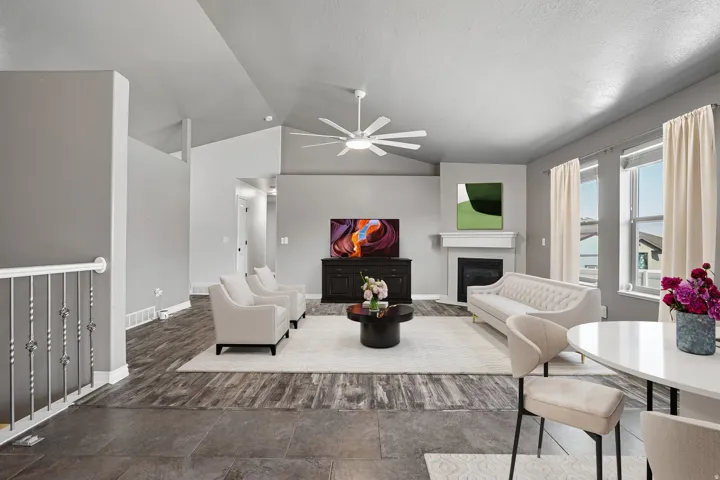 Vaulted ceilings and a ceiling fan enhance the living space, complemented by wood-finish flooring