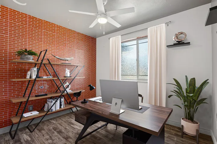 Wood-finish flooring with a textured accent wall, featuring a window with privacy film and a ceiling fan with integrated lighting