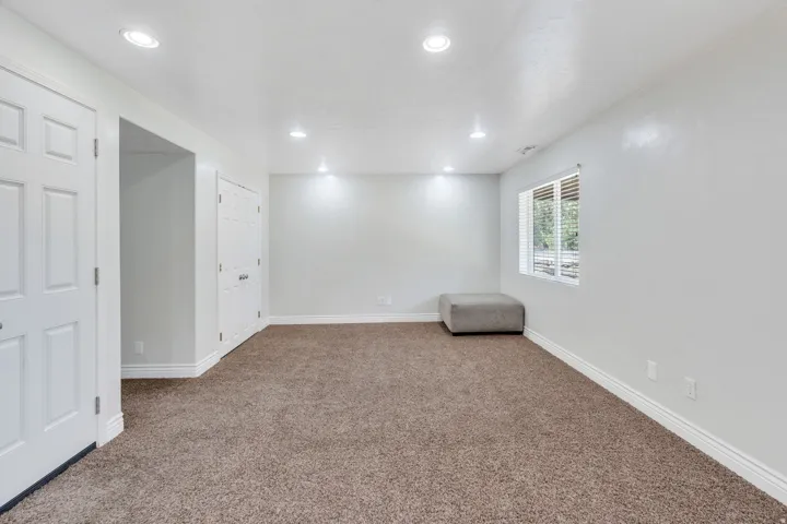 Spacious recreational room featuring neutral wall finishes, recessed ceiling lighting, and plush carpet flooring