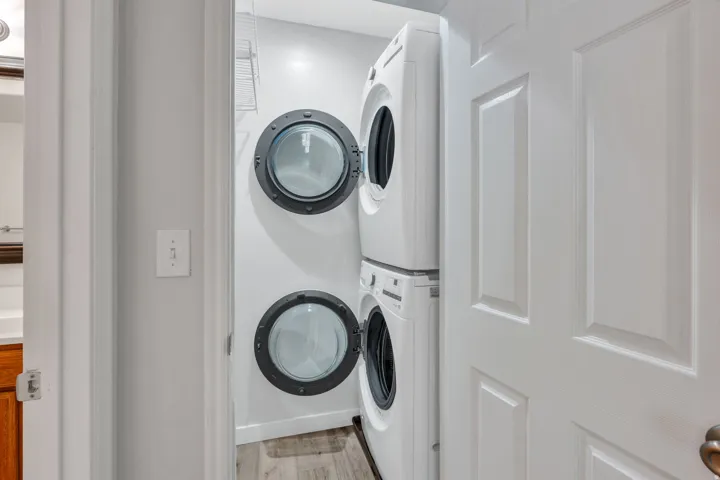 Dedicated laundry area featuring a stacked front-load washer and dryer (which stay)