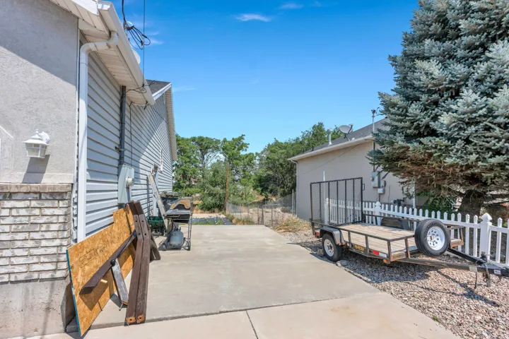 Spacious concrete driveway with direct access to detached garage and storage structures