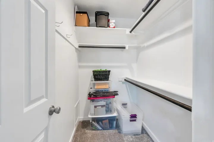 Dedicated master walk-in closet featuring built-in shelving, multiple organizational compartments, and durable flooring