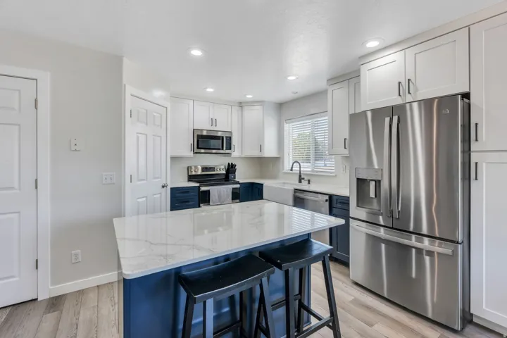 Modern kitchen featuring white shaker cabinetry, stainless steel French-door refrigerator, and built-in microwave