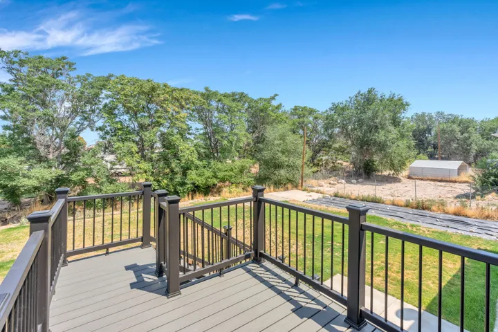 Elevated composite deck with black metal railings and horizontal balusters overlooking expansive grounds