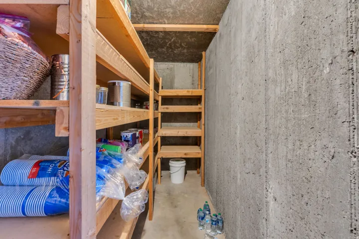 Concrete wall construction with built-in wooden shelving for storage