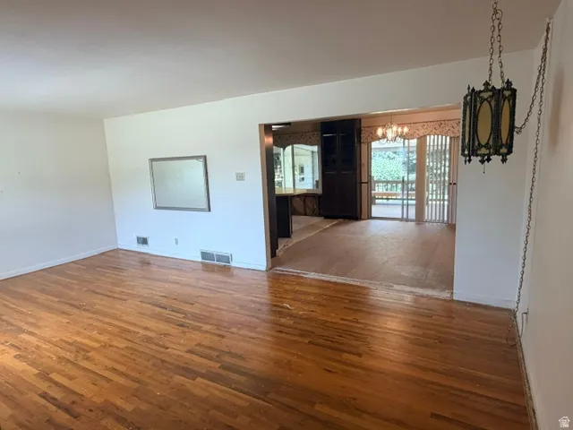 Front living room with hardwood floors and adjoining dining/kitchen from the front door entry .