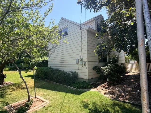 Two-story exterior featuring light-colored horizontal siding and a gable roofline in the backyard.