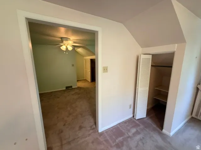 Upstairs bedroom featuring sloped ceilings and closet leading to the bonus room/home office adjoining the upstairs bedroom.