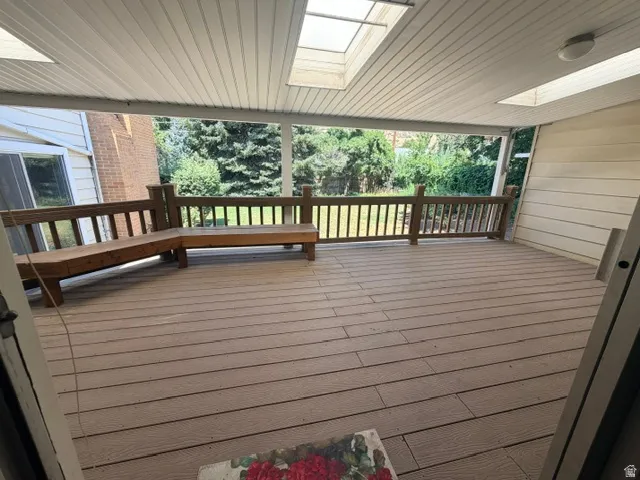 Covered outdoor deck with composite decking and integrated wooden benches.