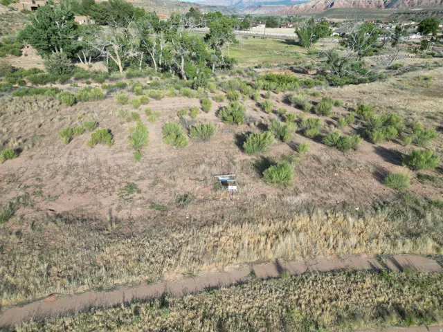 Expansive land with varied topography, featuring natural vegetation and distant mountainous terrain