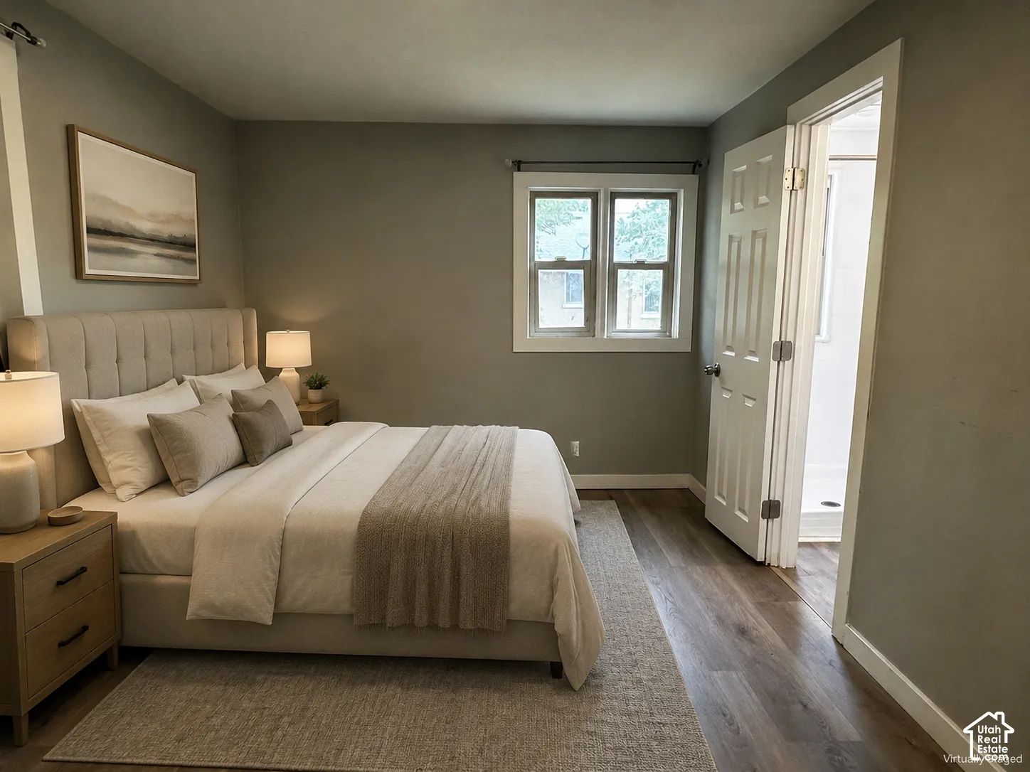 Wood-finish flooring, white window trim, and a paneled interior door