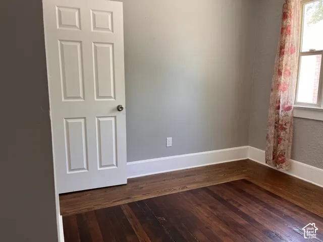 (Front Unit) Hardwood flooring with a rich finish, crisp white trim, and a classic paneled door