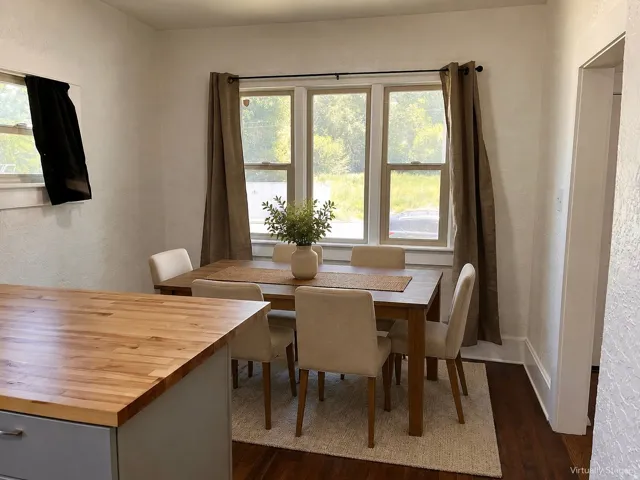 Wood-finish flooring, white trim, and a window frame with multiple panes